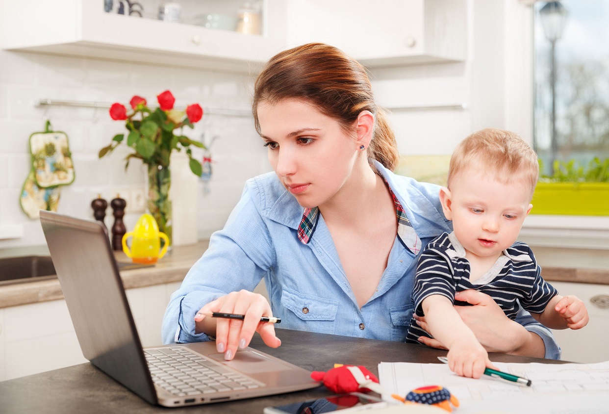 young mother working with her baby at home