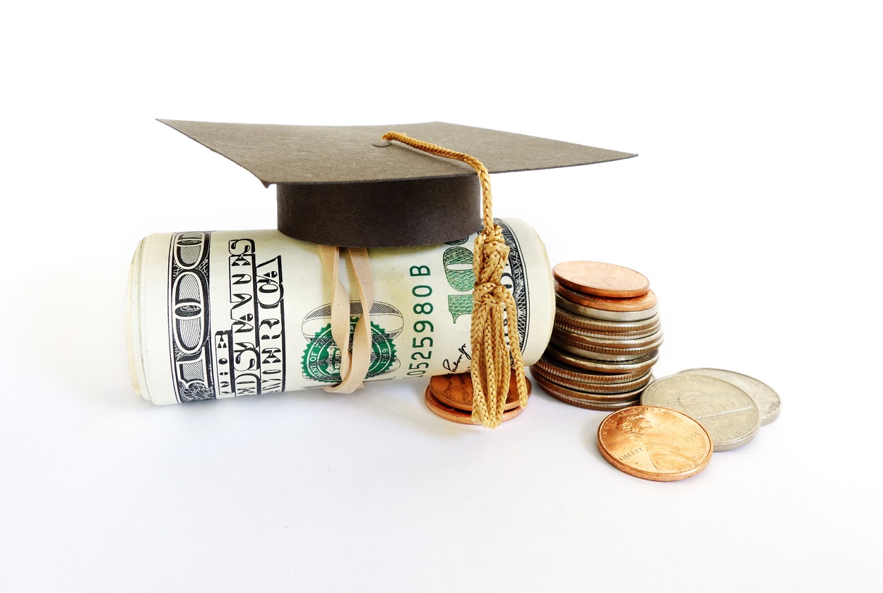 mini graduation cap with financial aid money and coins