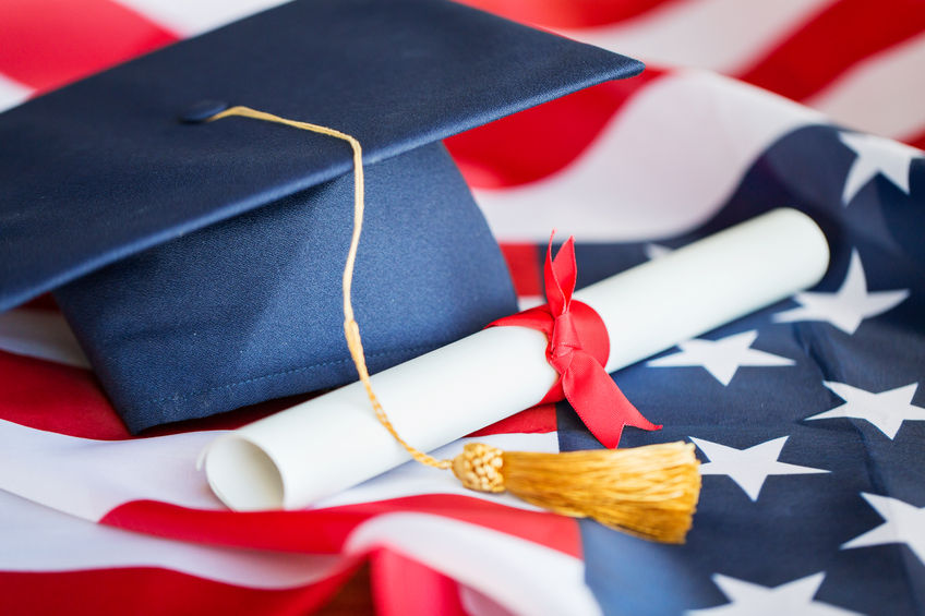 bachelor hat and diploma on american flag