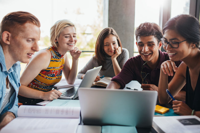 multiracial group of young students studying in the library