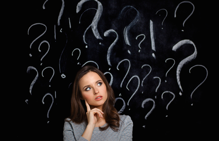 young girl with question mark on a gray background