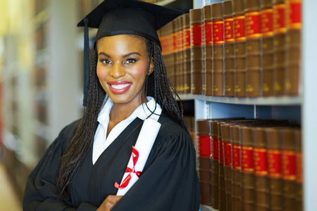 beautiful african female graduate in library on graduation day