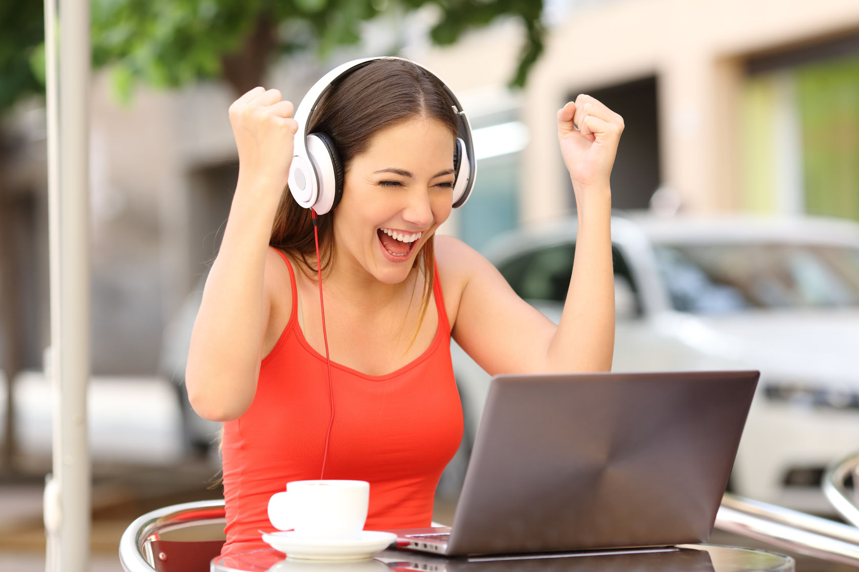 winner girl euphoric watching a laptop in a coffee shop wearing a red shirt concept for scholarships for online students