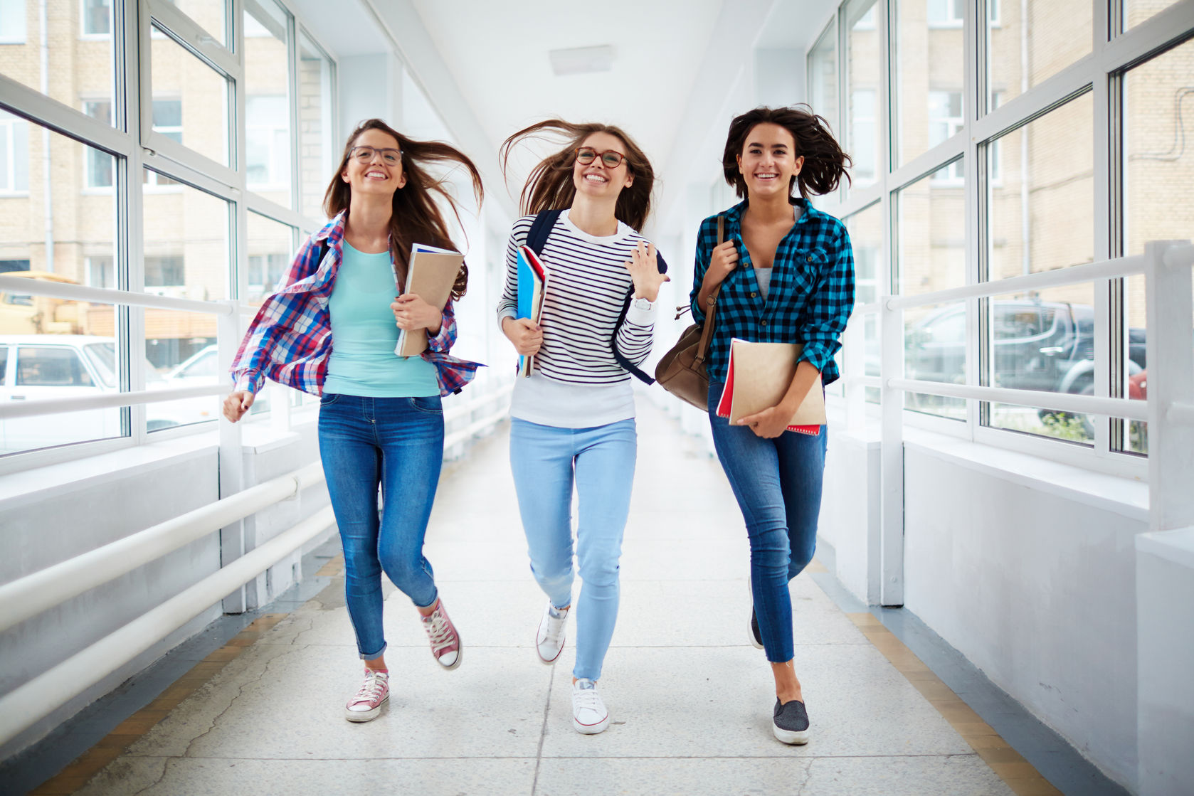 three hurrying girls running for college class concept for scholarships for women