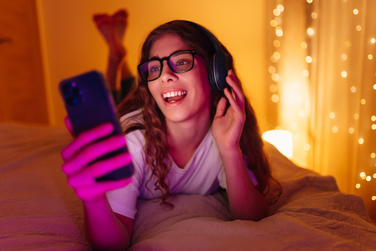 oung woman in headphones before bedtime listening online to relaxing music and chatting.