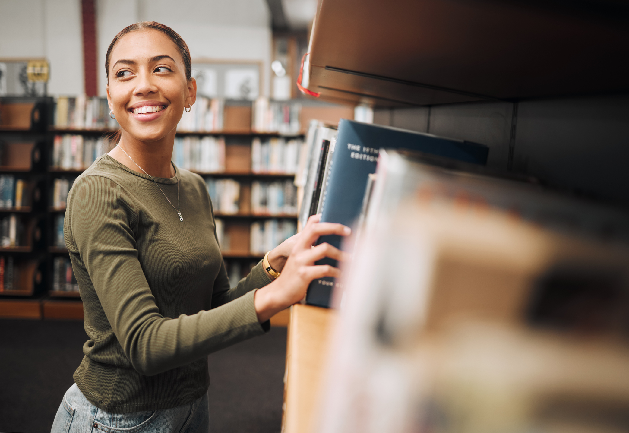 Student woman, search bookshelf and library for study, research and knowledge at university. College student, information and studying for education, college and learning for scholarship in Atlanta