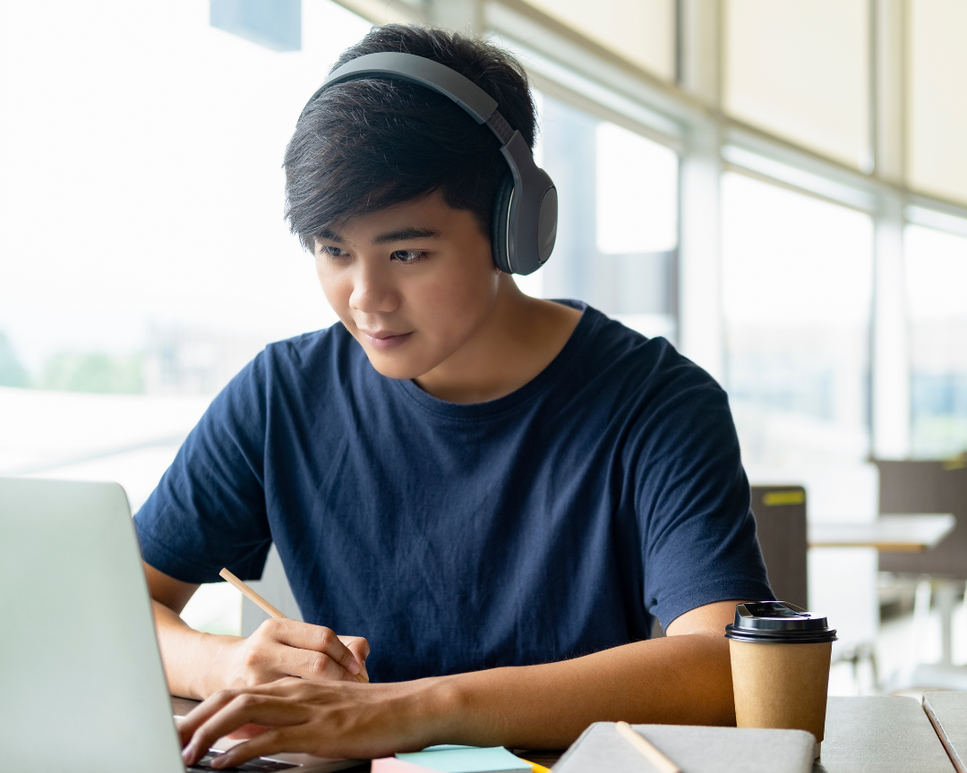 teen on laptop typing his college application