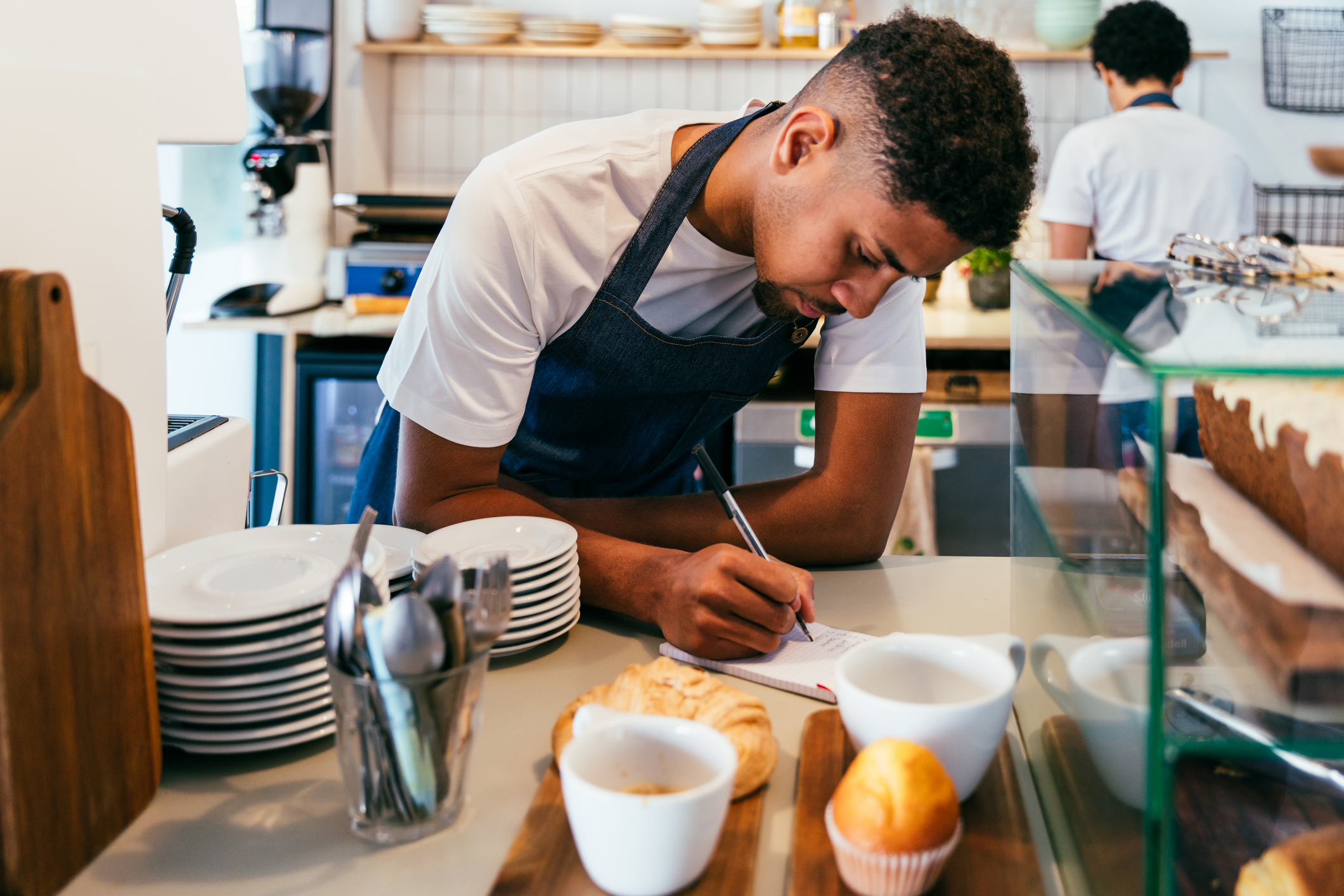 Barista and waiter working in a bar cafeteria shop