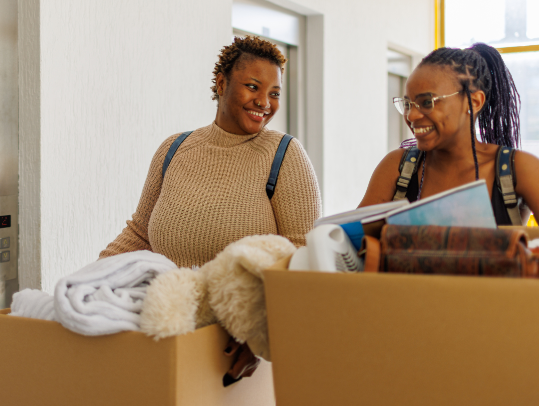 Mom and daughter carrying moving boxes - move to college