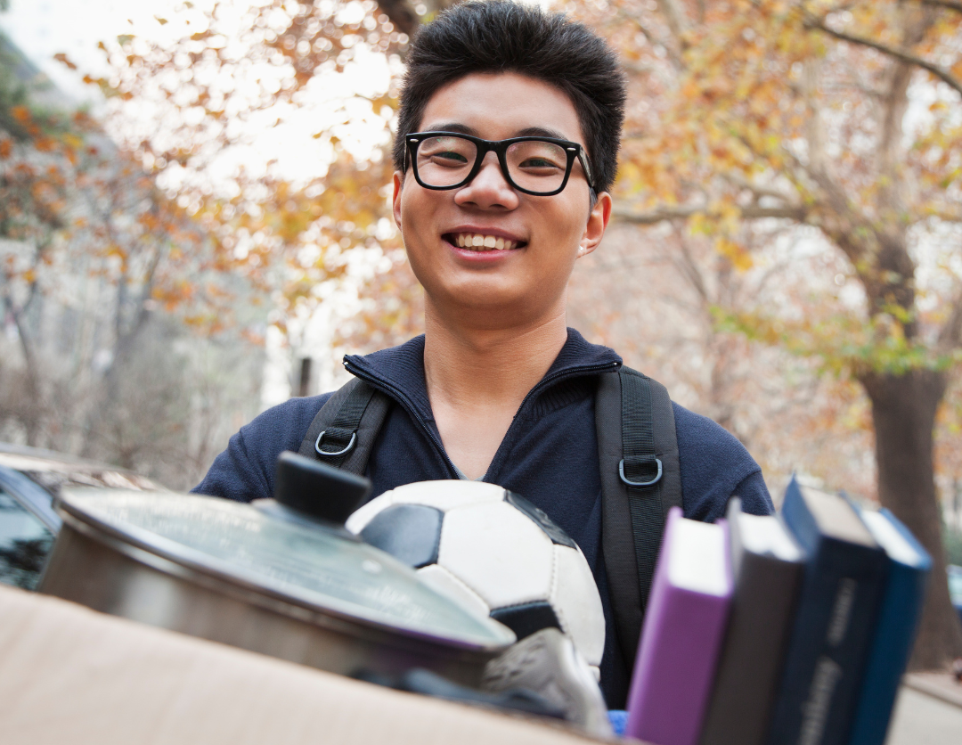 college student holding moving box for move to college