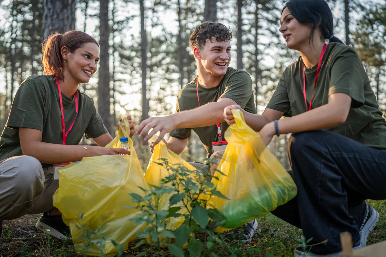 teenage friends young men women pick up waste garbage to clean forest