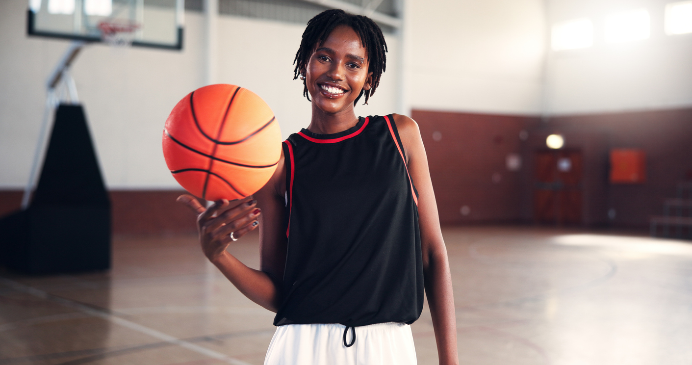 Portrait, basketball and happy black woman at court for sports, workout or practice for training. Player, athlete and person with ball in gym for fitness, competition and wellness with confidence